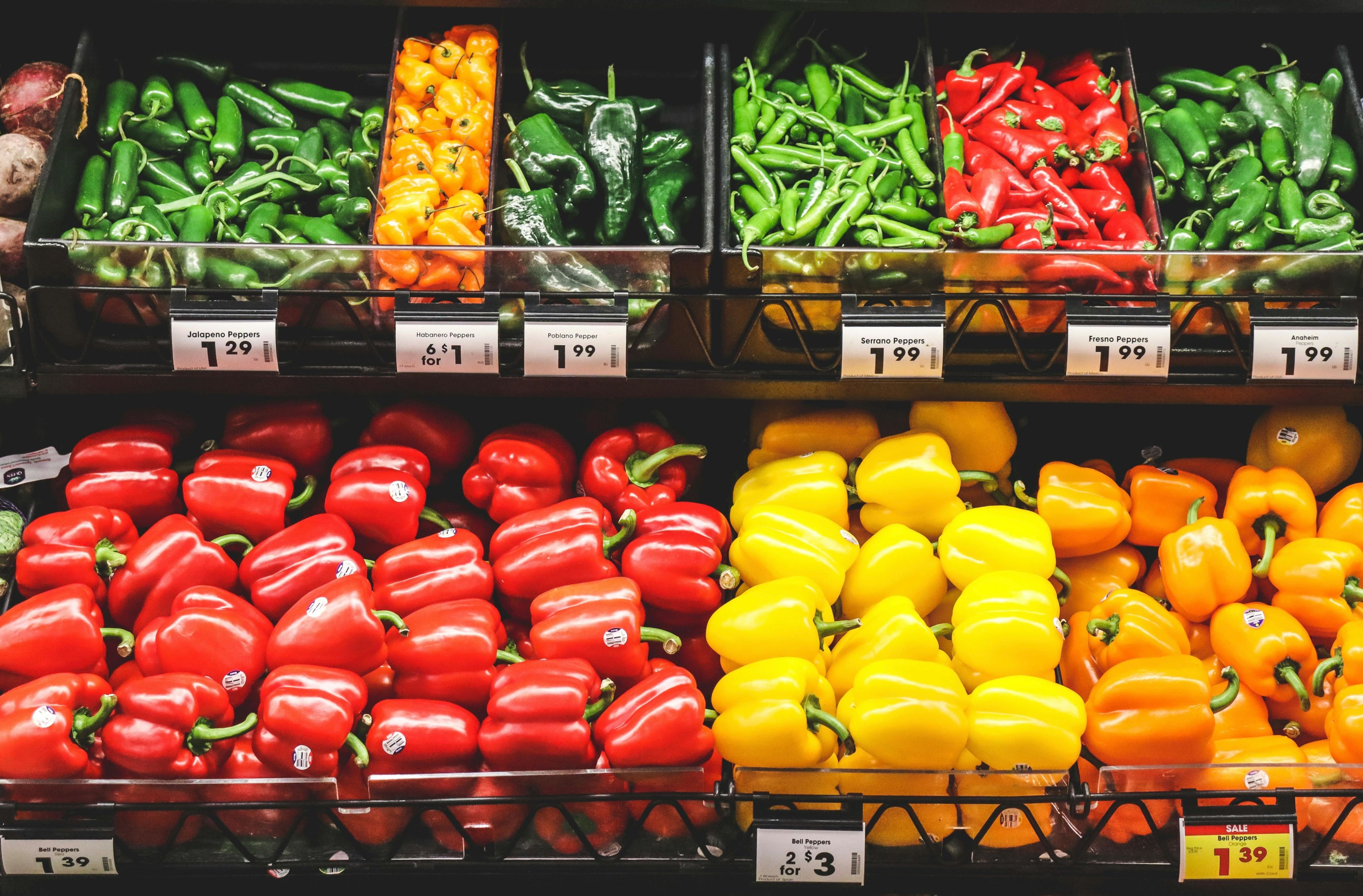 Vibrant variety of peppers on supermarket shelves. Perfect for healthy food and grocery themes.