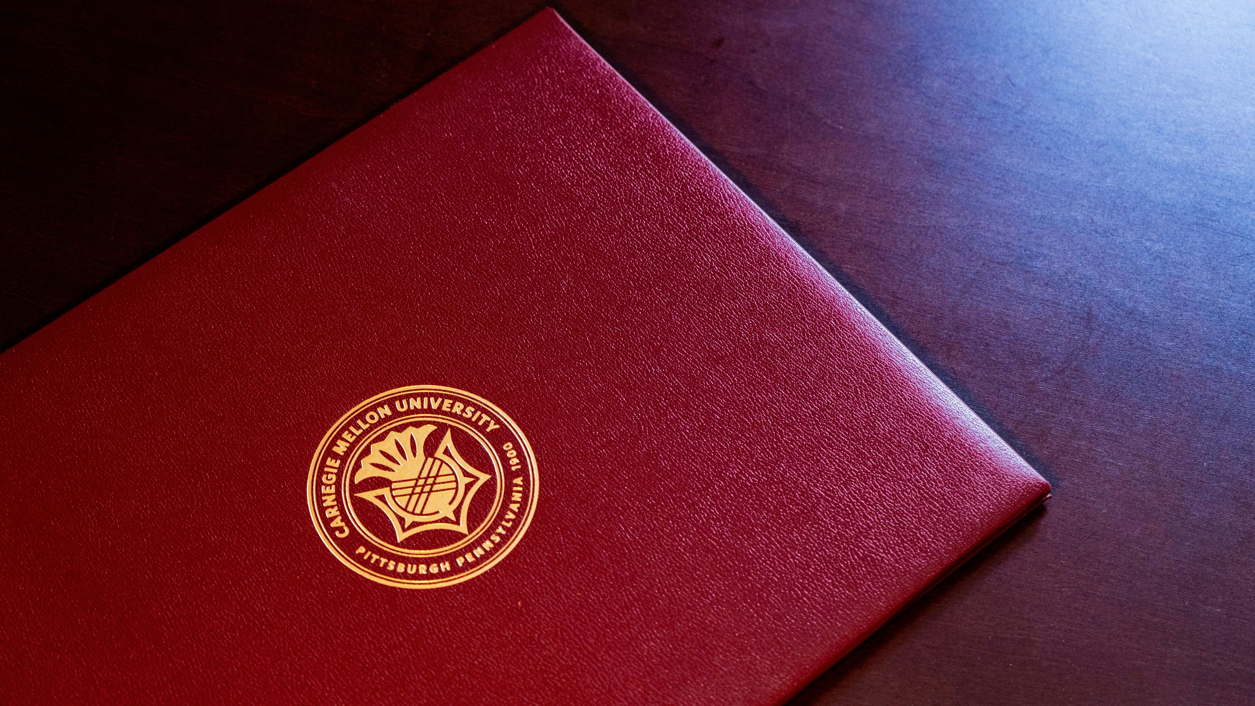 red and gold book on black textile