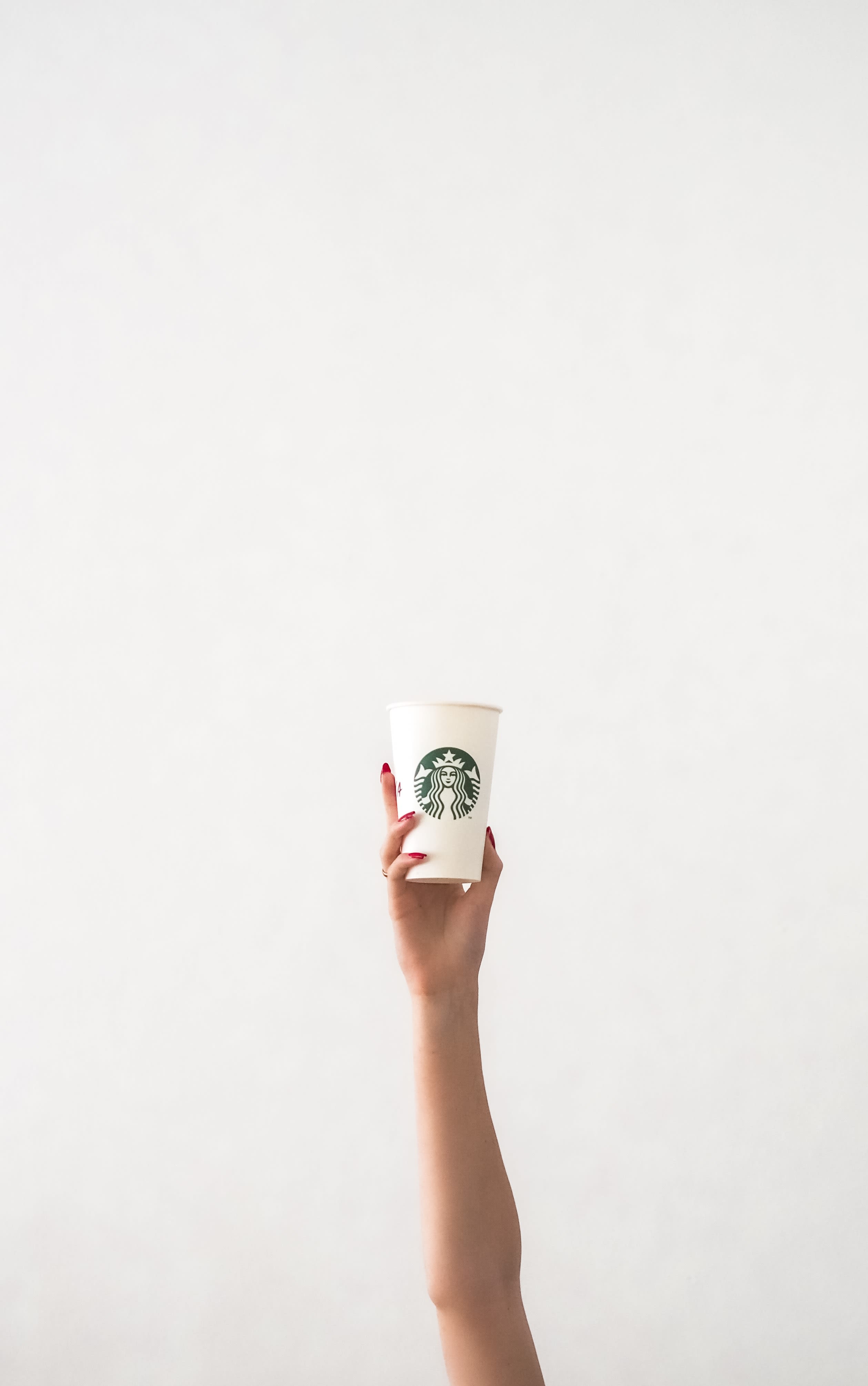 person holding white plastic cup
