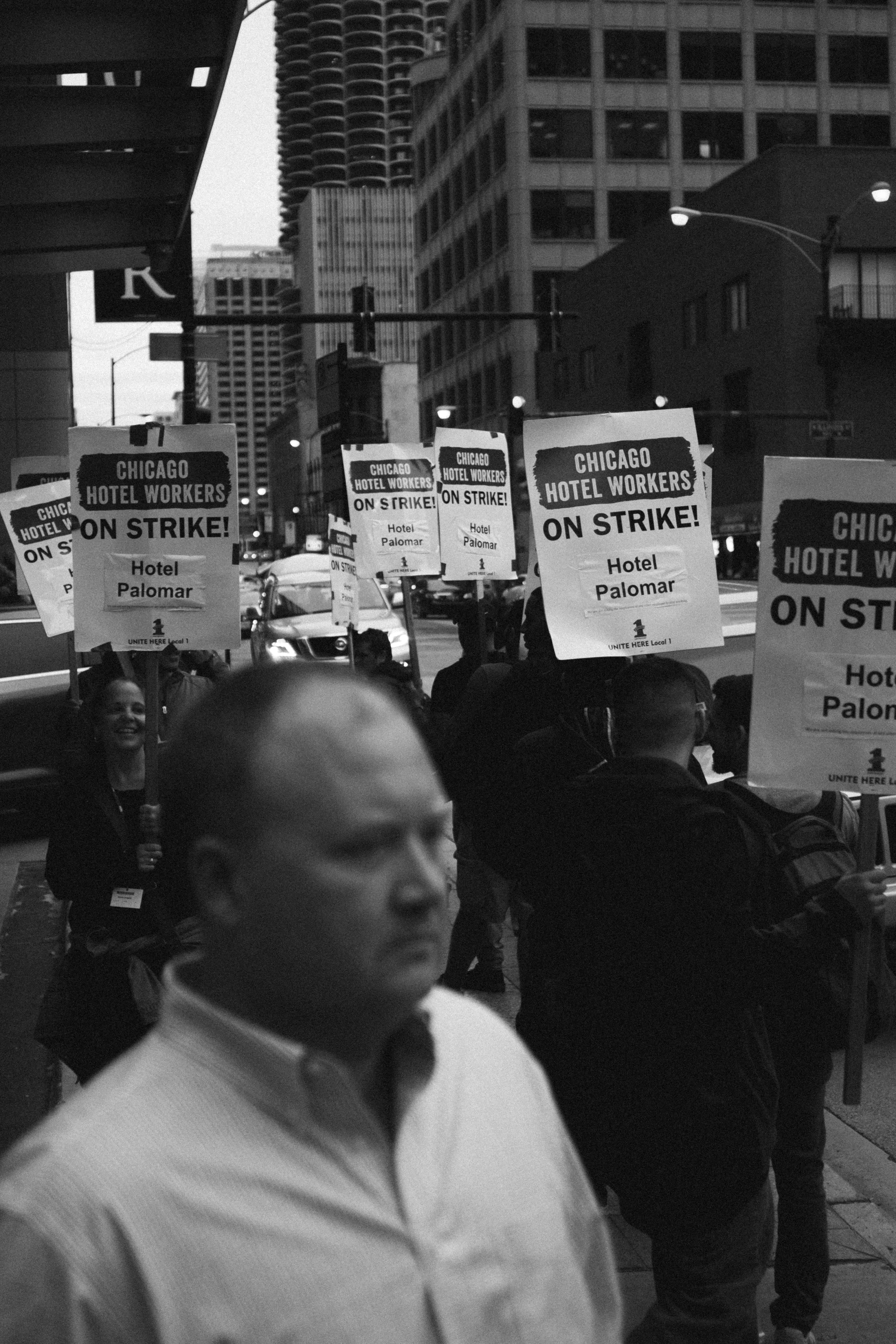 greyscale photo of man wearing dress shirt near signage