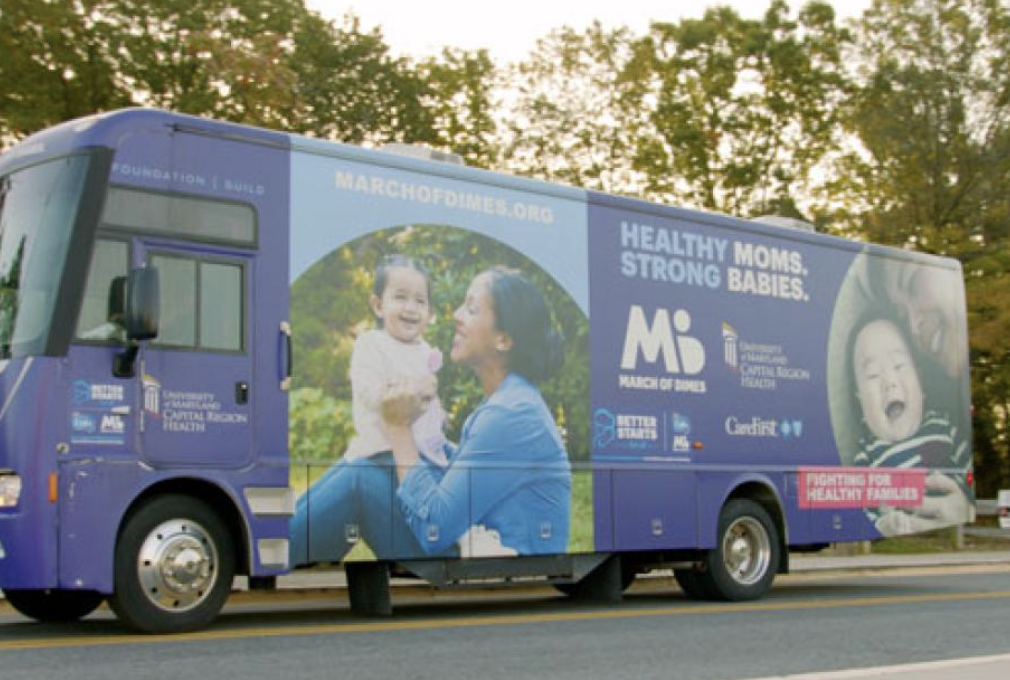 person in red sweater holding babys hand